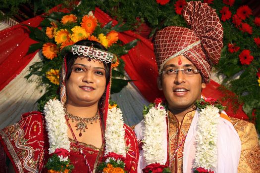 A portrait of an Indian wedding couple in their traditional attire.