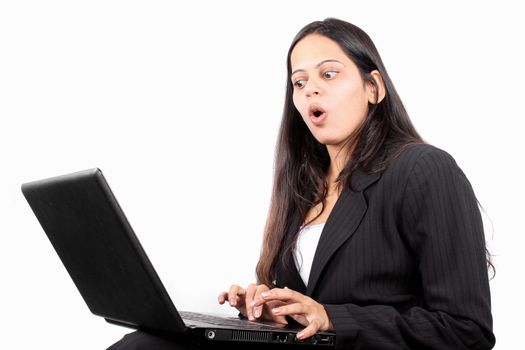 A businesswoman shocked looking her business report on the laptop.