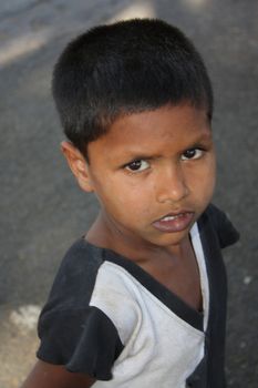 A poor walking streetside boy in India. Focus on lips.