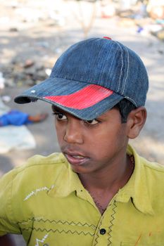 A portrait of a poor Indian boy wearing a cap.