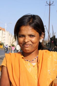 A portrait of a smiling poor Indian teenage girl.