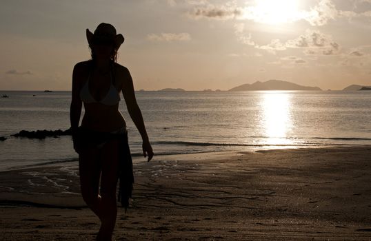 Silhouette of a woman strolling along the beach of Ko Lipe Island in Thailand