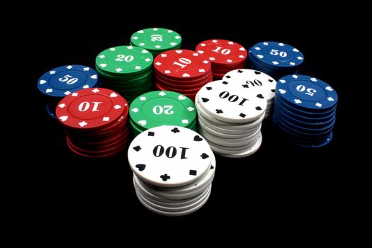 Stacks of colorful casino counters, isolated on black background.