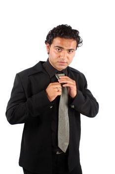 A handsome Indian businessman getting ready wearing a necktie for his office, on white studio background.