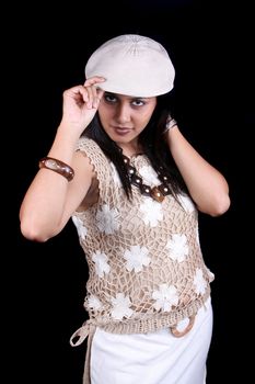 A glamorous Indian babe wearing a stylish hat, on black studio background.