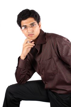 A portrait of a young Indian businessman, posing on a white studio background.