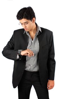 A young Indian businessman checking time in his watch, on white studio background.