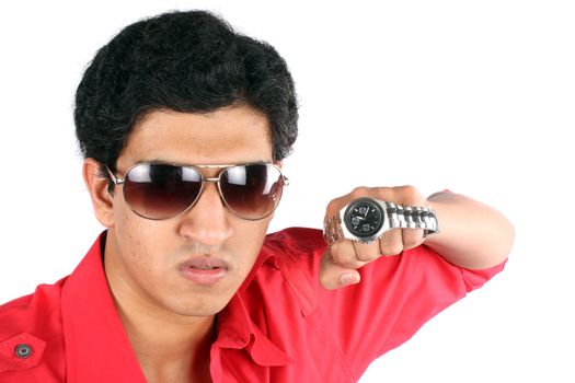 A metaphorical portrait of a young Indian man wearing a trendy watch 'punching through the time', on white studio background.