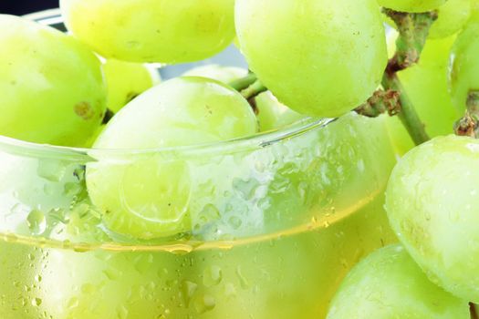 White grapes in a wine glasses with grape juice.