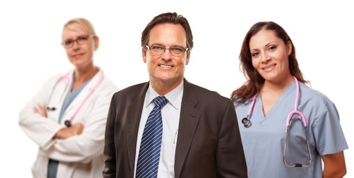 Smiling Businessman in Suite and Tie While Female Doctor and Nurse Stand Behind Isolated on a White Background.