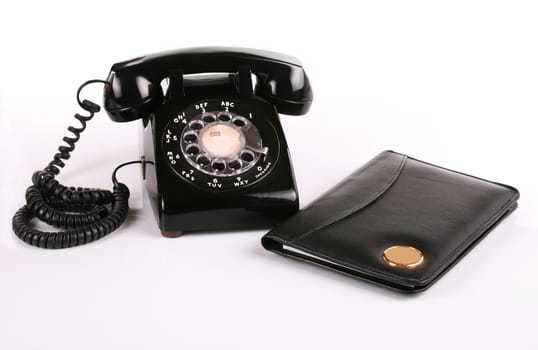 Old fashioned black rotary phone and notepad