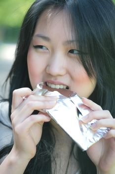 beautiful orient girl eats chocolate
