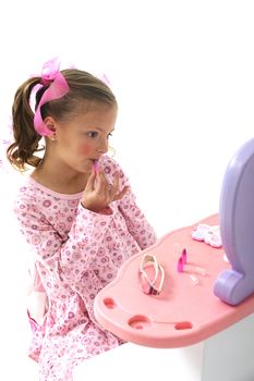 young pretty blond girl putting make-up on her face while sitting at a play set
