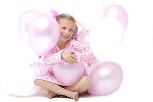 a pretty young blond girl sitting between pink and white balloons