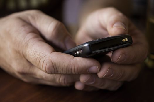 large Caucasian male hands close up dialing on a mobile phone