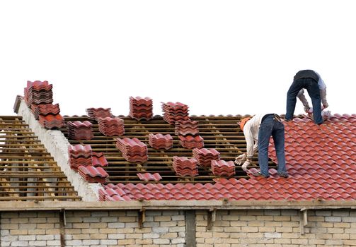 Image of workers laying roof tiles on an house under construction.