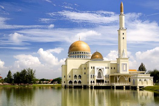 Floating mosque with gold coloured domes and minaret in Malaysia.
