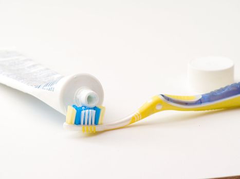 Close up of a toothbush and toothpaste on  white