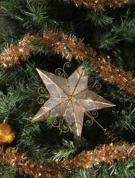 Star surrounded by pine and christmas ornaments