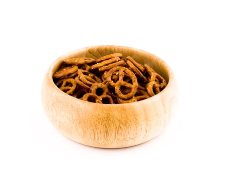 Tasty pretzels in wooden bowl on white background.