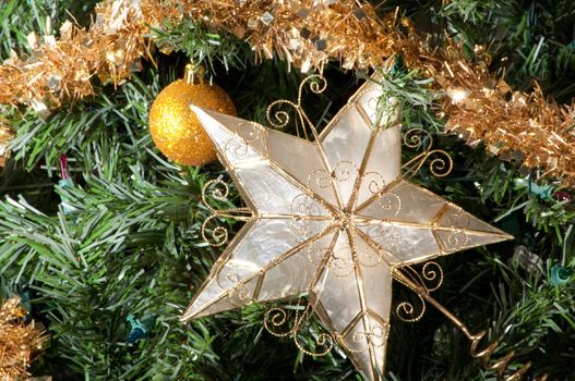 Christmas tree detail with star and ball ornaments.