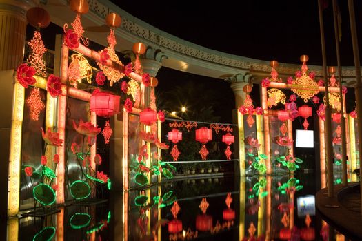 Night image of Chinese New Year lanterns and lights by a pool.