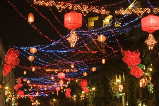 Night image of a street decorated with lanterns and lights during Chinese New Year in Malaysia.