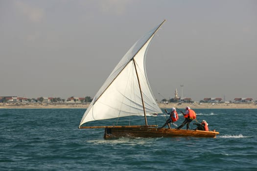 Young sailors in a traditional racing dhow in the Arabian Gulf, off Dubai.