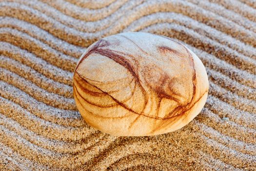 The beautiful figured stone easy lays on sand