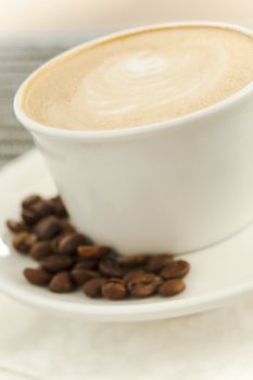 Close up of a cup of coffee latte with beans