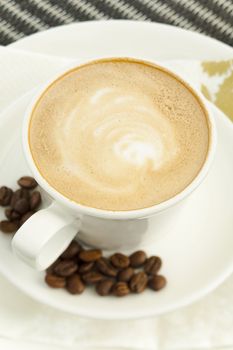 Coffee with foam and beans on the table