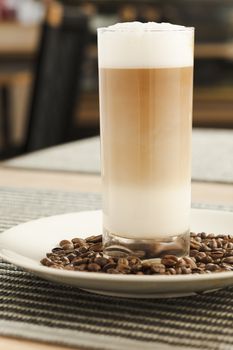 Latte on the tall glass on the table