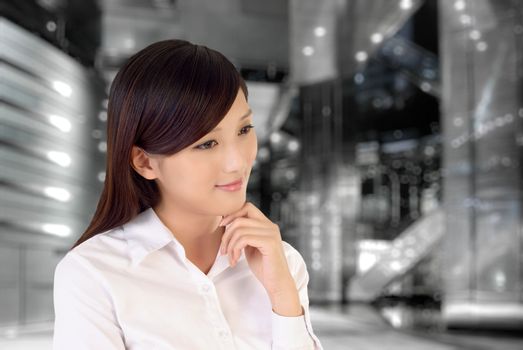 Businesswoman thinking inside of modern architecture, closeup portrait of oriental office lady.