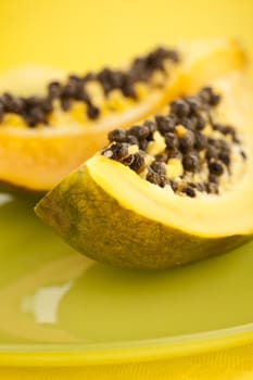 Papaya halves on the green glass plate