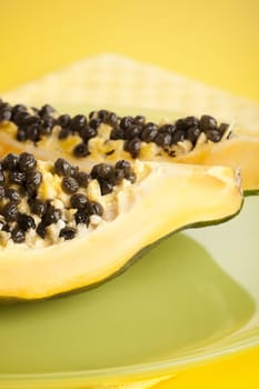 Papaya halves on the green glass plate