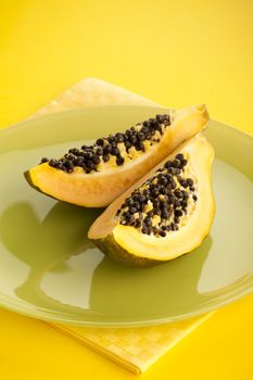 Papaya halves on the green glass plate