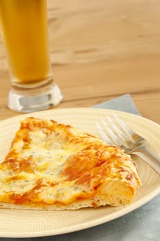 Hot pizza on the plate with cold beer