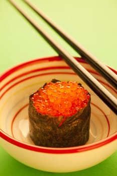 Salmon roe  seaweed sushi roll on the green table