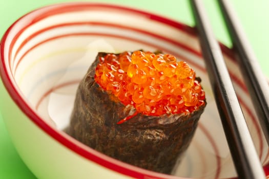 Salmon roe  seaweed sushi roll on the green table