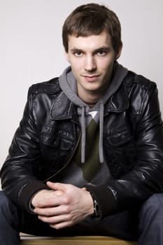 Portrait of a handsome young man sitting on the bench