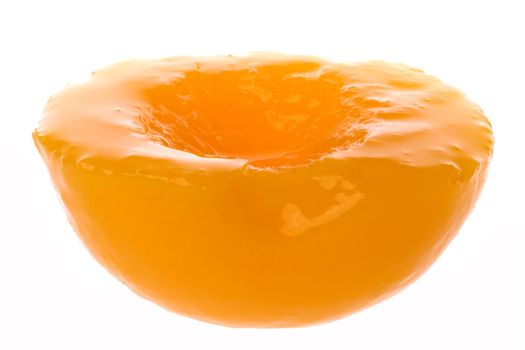 Isolated image of canned a peach half in syrup.