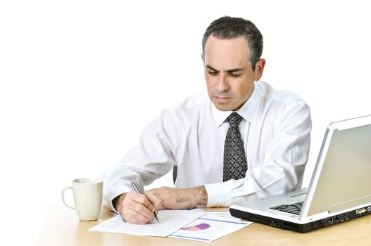 Serious office worker reviewing generic reports at his desk