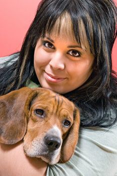 A pretty young woman posing with her beagle pup.