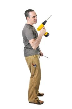 Confident handyman holding a drill and screwdriver