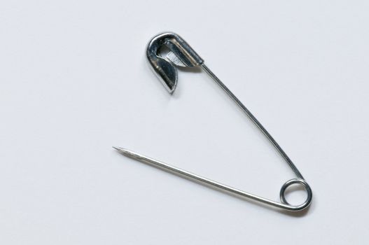 Isolated, open safety pin in white background