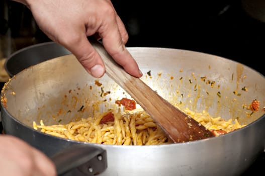 Cooking a first course with pasta, shrimps and vegetables