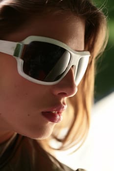 close-up portrait of the beautiful young brunette in sunglasses 