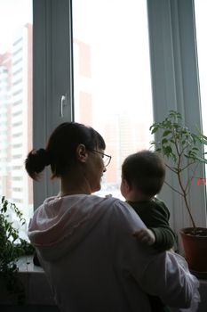 mother and small son beside it on hand near window