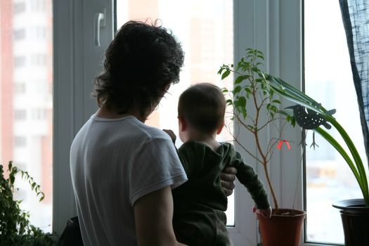 father and small son beside it on hand near window