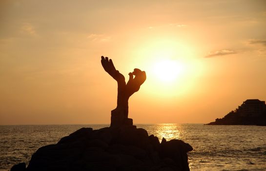 Silhouette of monument during sunset over the beach of Puerto Escondido